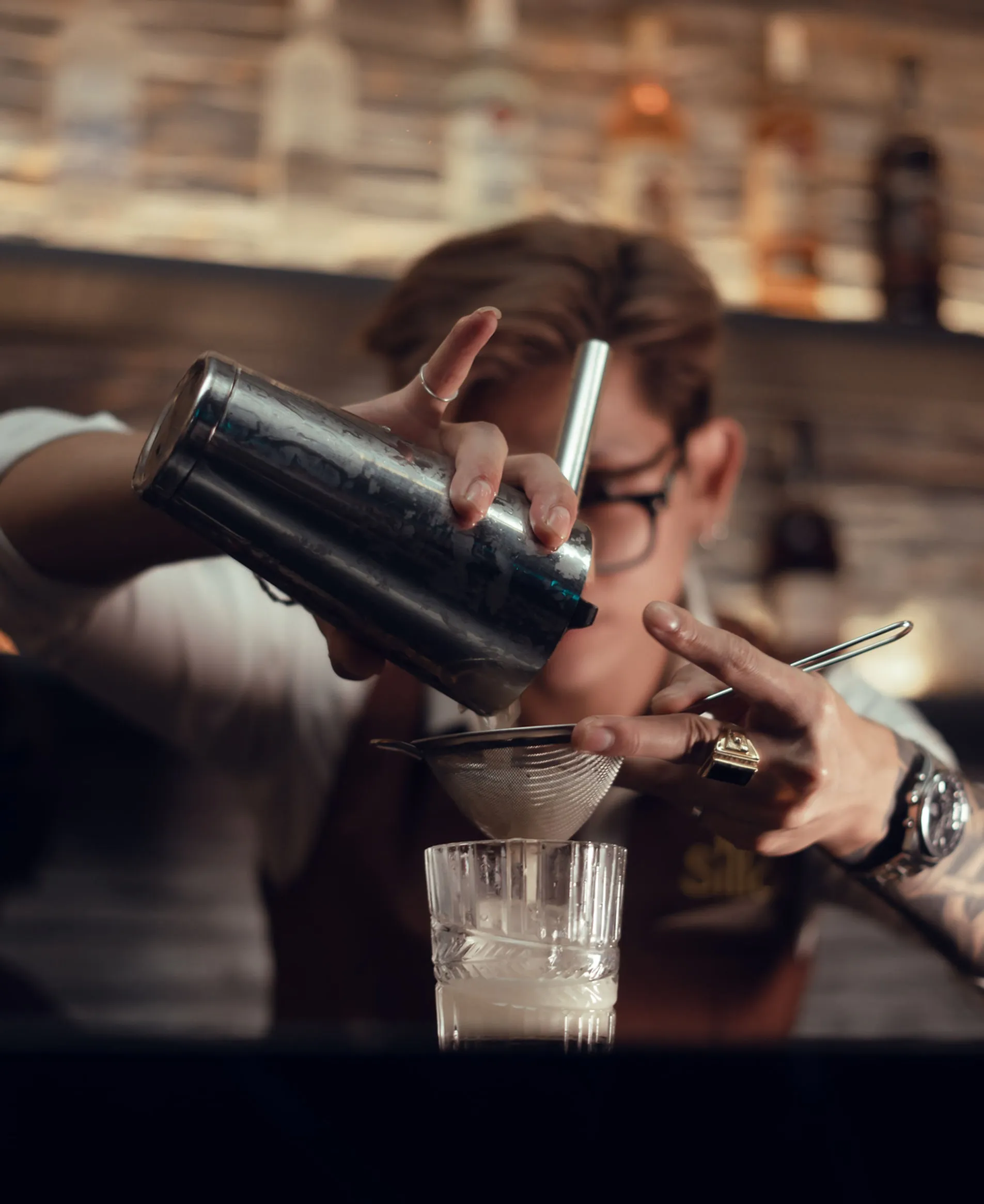 Silk Lounge bartender straining a handcrafted cocktail through fine mesh sieve